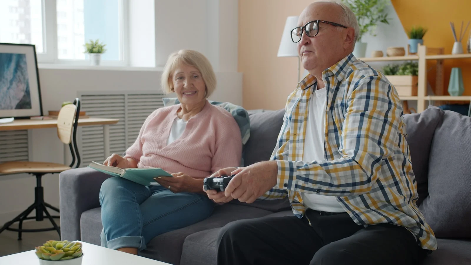 Elderly couple playing video games on the couch. Elderly couple playing video games on the couch.