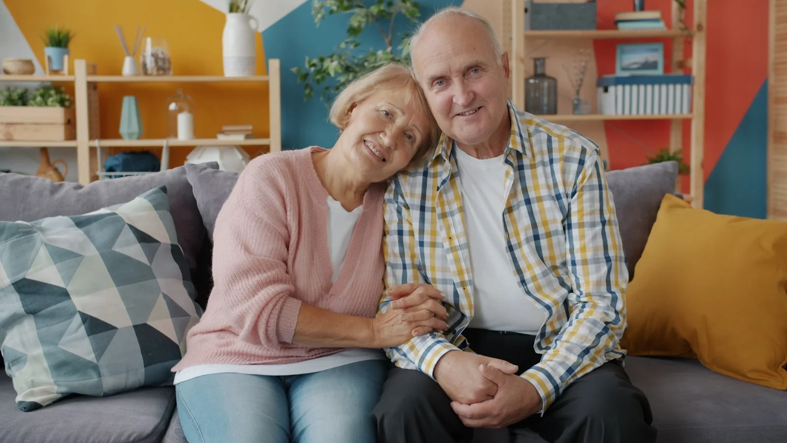Elderly couple smiling on a couch Elderly couple smiling on a couch