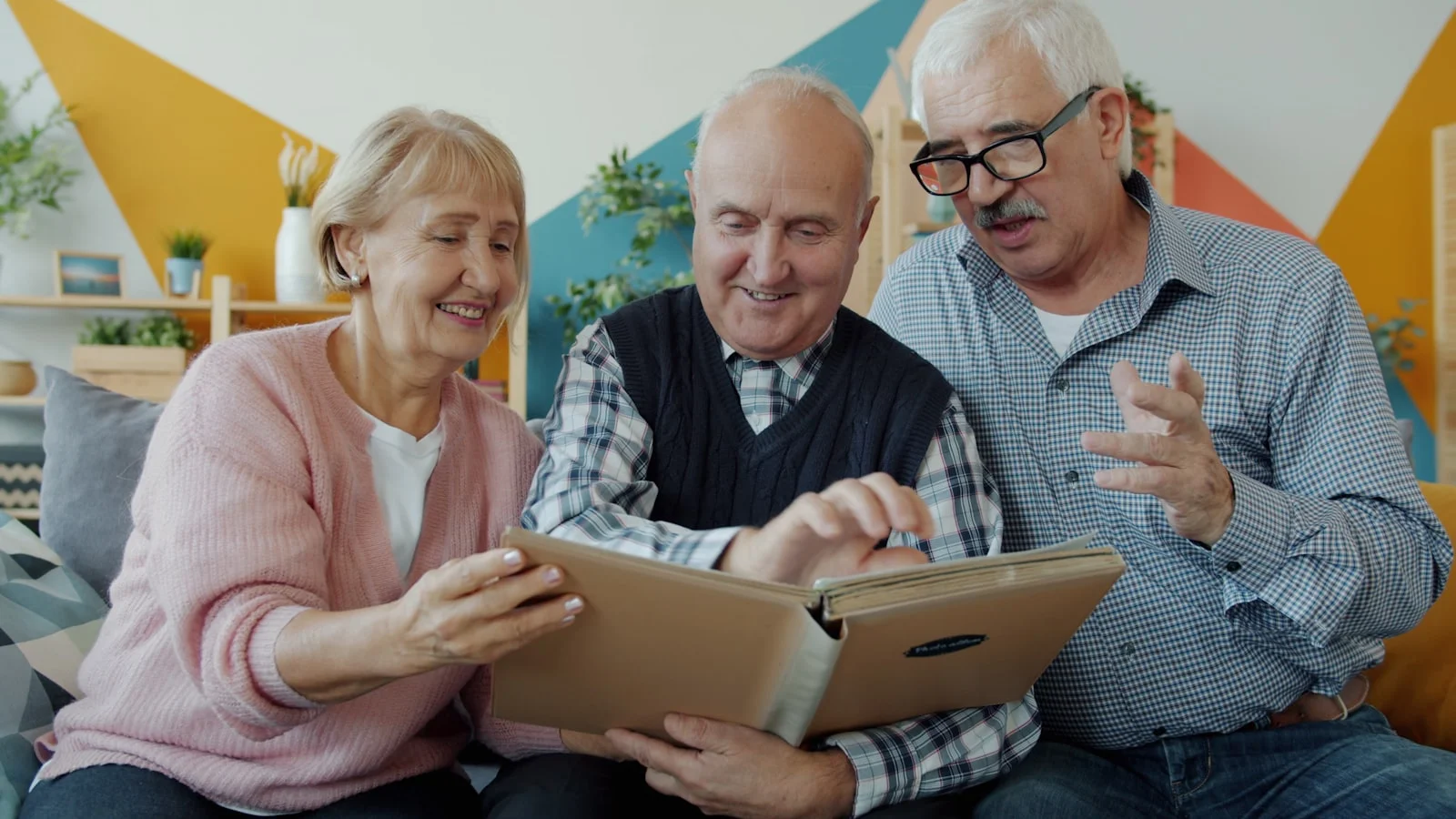 Three seniors looking at a photo album together Three seniors looking at a photo album together
